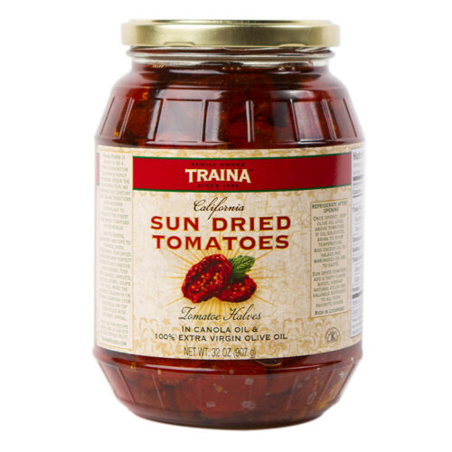 Close-up of Traina® Home Grown California Sun Dried Tomatoes in Oil, Halves, packed in a 32 oz glass jar with a secure twist lid. Featuring bold tomato flavor, a subtle spice blend, vibrant color, and tender texture, these tomatoes are a versatile option for home chefs, ready to use in appetizers, charcuterie boards, or to enhance recipes with heart-healthy, gluten-free ingredients.