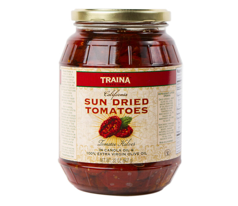 Close-up of Traina® Home Grown California Sun Dried Tomatoes in Oil, Halves, packed in a 32 oz glass jar with a secure twist lid. Featuring bold tomato flavor, a subtle spice blend, vibrant color, and tender texture, these tomatoes are a versatile option for home chefs, ready to use in appetizers, charcuterie boards, or to enhance recipes with heart-healthy, gluten-free ingredients.